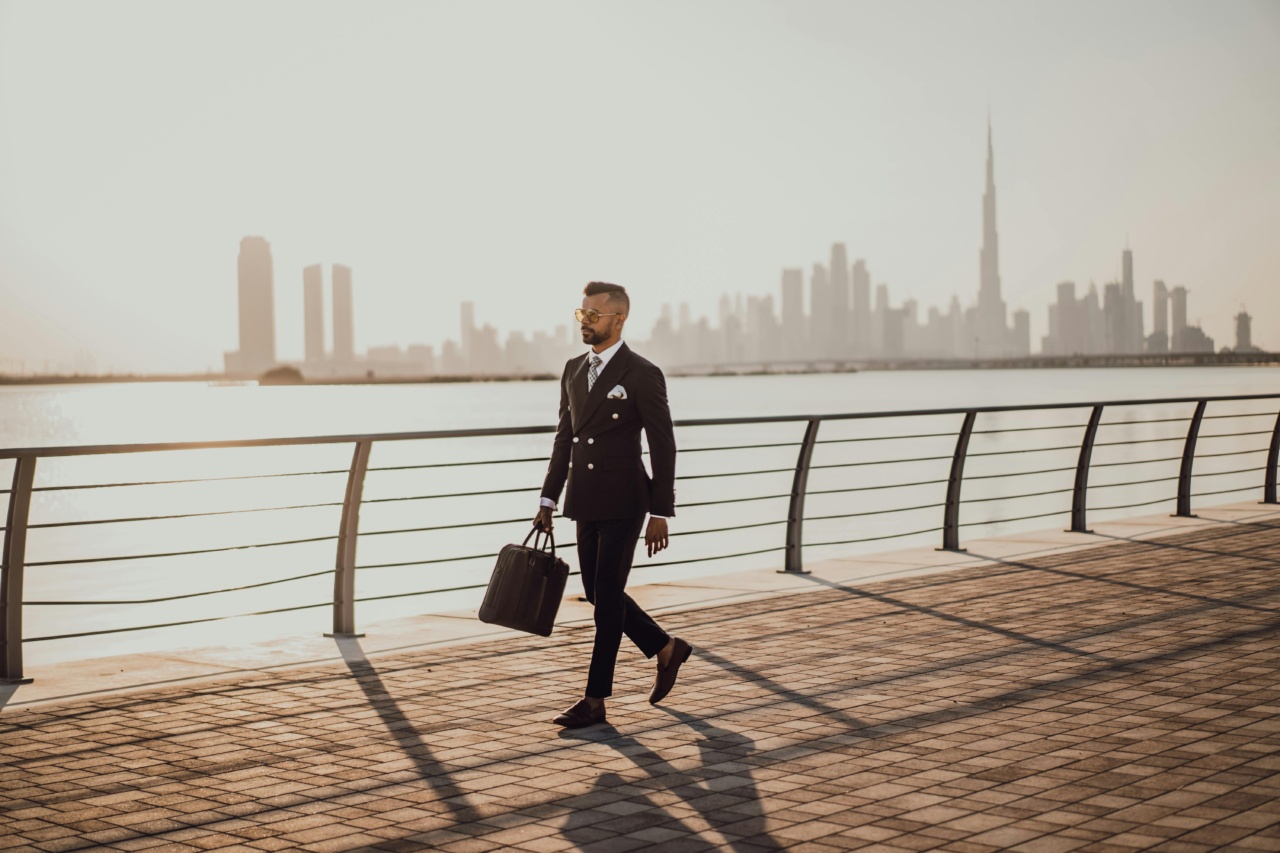 A sharp dressed business man walks by the sea with the Dubai skyline in the background, representing internal comms in the UAE